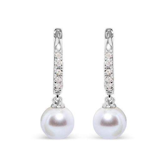 Front-facing view of white metal earrings with a hoop section featuring rows of small white gemstones in pave settings, each earring holding a single round white pearl drop.