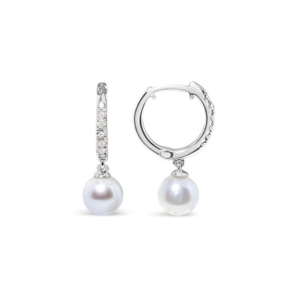 Pair of white metal hoop earrings with small white gemstones set on the front, each featuring a single round white pearl drop, shown from front and side angles on a white background.
