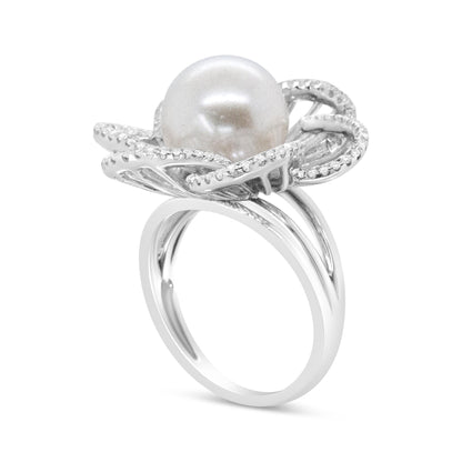White metal ring angled to show side and top view, featuring a large central pearl surrounded by a flower-shaped design lined with small white gemstones in pave setting.