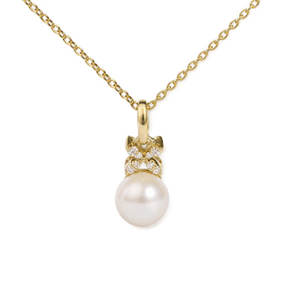 Close-up front view of a yellow metal necklace with a pendant featuring white gemstones and a large round pearl, shown on a white background.