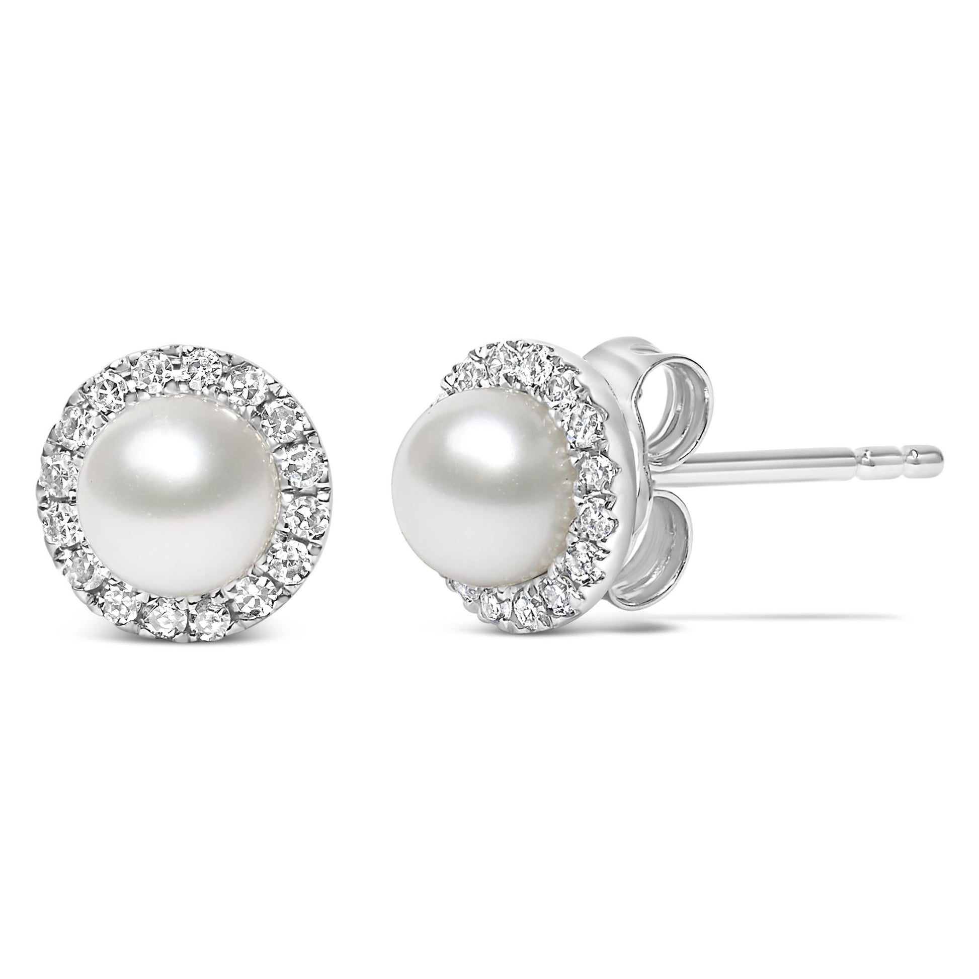 Close-up front and side view of a pair of white stud earrings with a central round white gemstone surrounded by a pave setting of small round white gemstones.