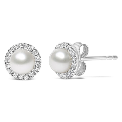 Close-up front and side view of a pair of white stud earrings with a central round white gemstone surrounded by a pave setting of small round white gemstones.