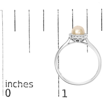 White metal ring featuring a central round beige pearl surrounded by small white gemstones in a micro-pave setting, shown on a scale from side angle.