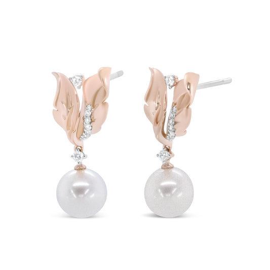 Front-facing close-up of a pair of rose metal earrings featuring leaf-shaped design with prong-set white round gemstones and a single large white round gemstone drop on each earring.