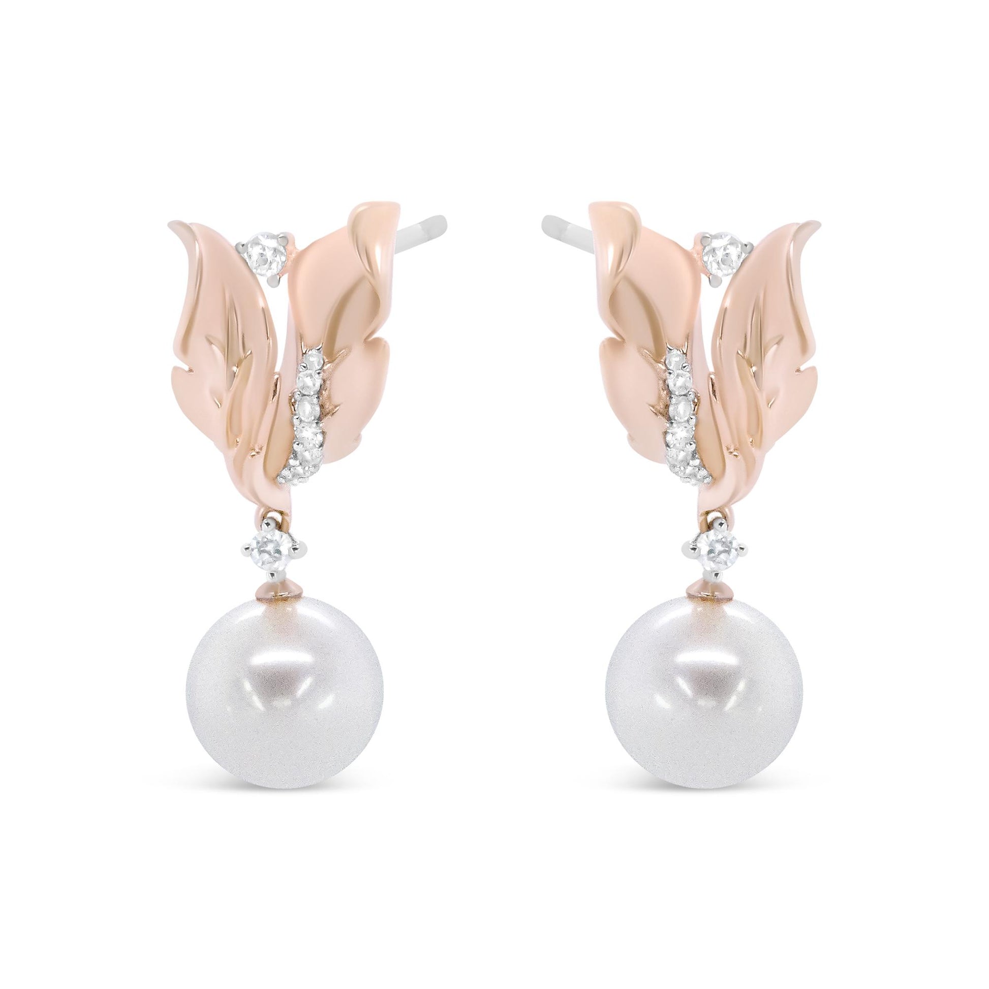 Front view of rose-colored metal earrings designed as leaves with white round gemstones in prong settings and large white round pearls hanging below.