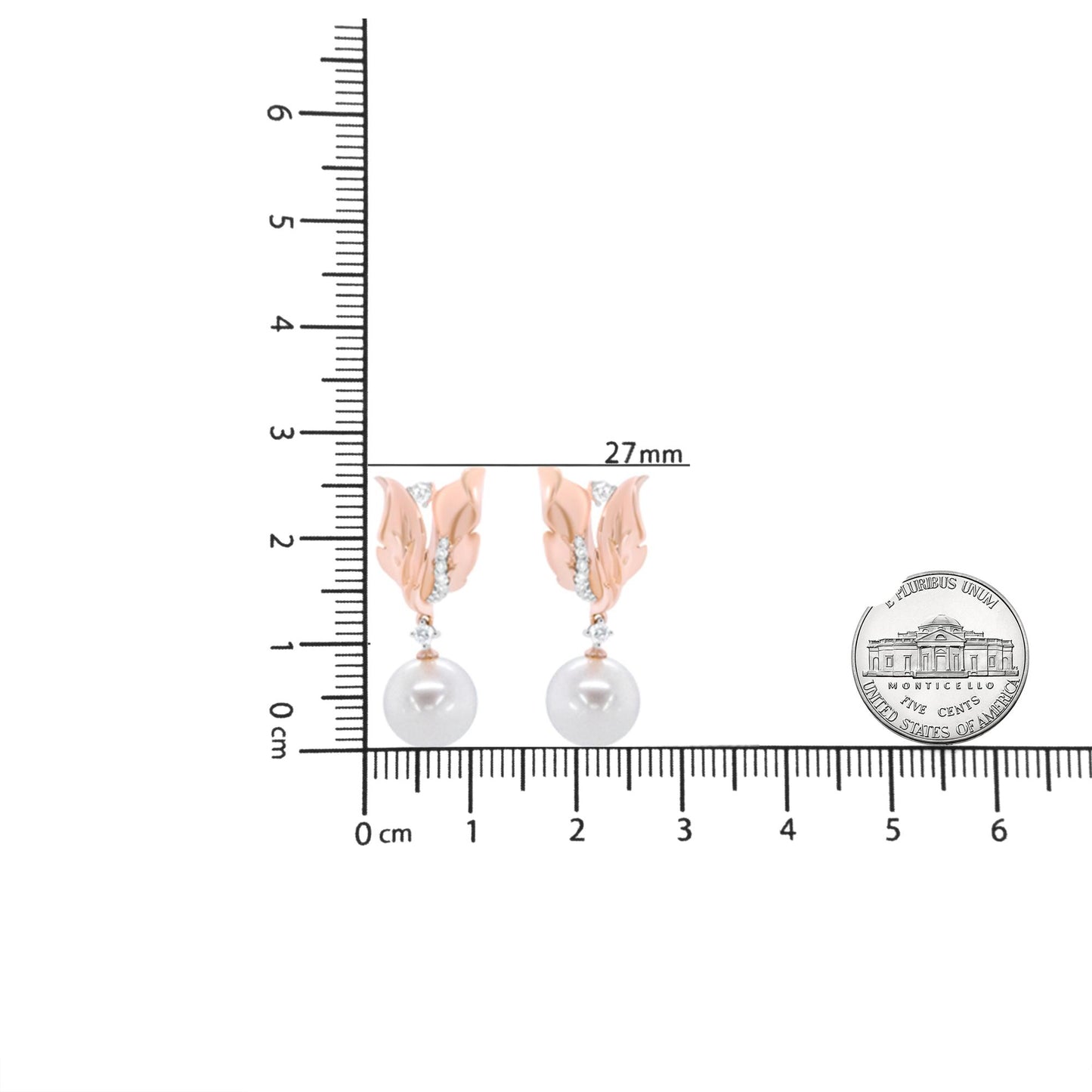 Front view of rose metal earrings with leaf design, multiple small white gemstones, and a hanging white pearl, shown on a ruler and next to a coin for size reference.