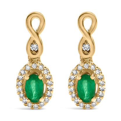 Front view of a pair of yellow metal earrings featuring an infinity loop design at the top with a single white gemstone in the center of the loop. Below the loop hangs an oval-shaped green gemstone surrounded by a pave setting of small white gemstones.