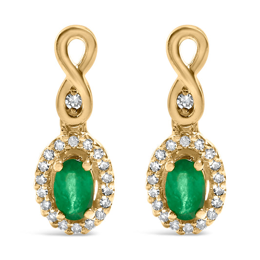 Front view of a pair of yellow metal earrings featuring an infinity loop design at the top with a single white gemstone in the center of the loop. Below the loop hangs an oval-shaped green gemstone surrounded by a pave setting of small white gemstones.