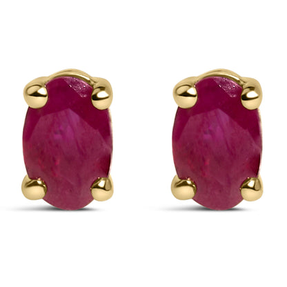 Front view of yellow metal stud earrings with oval red gemstones in prong settings.