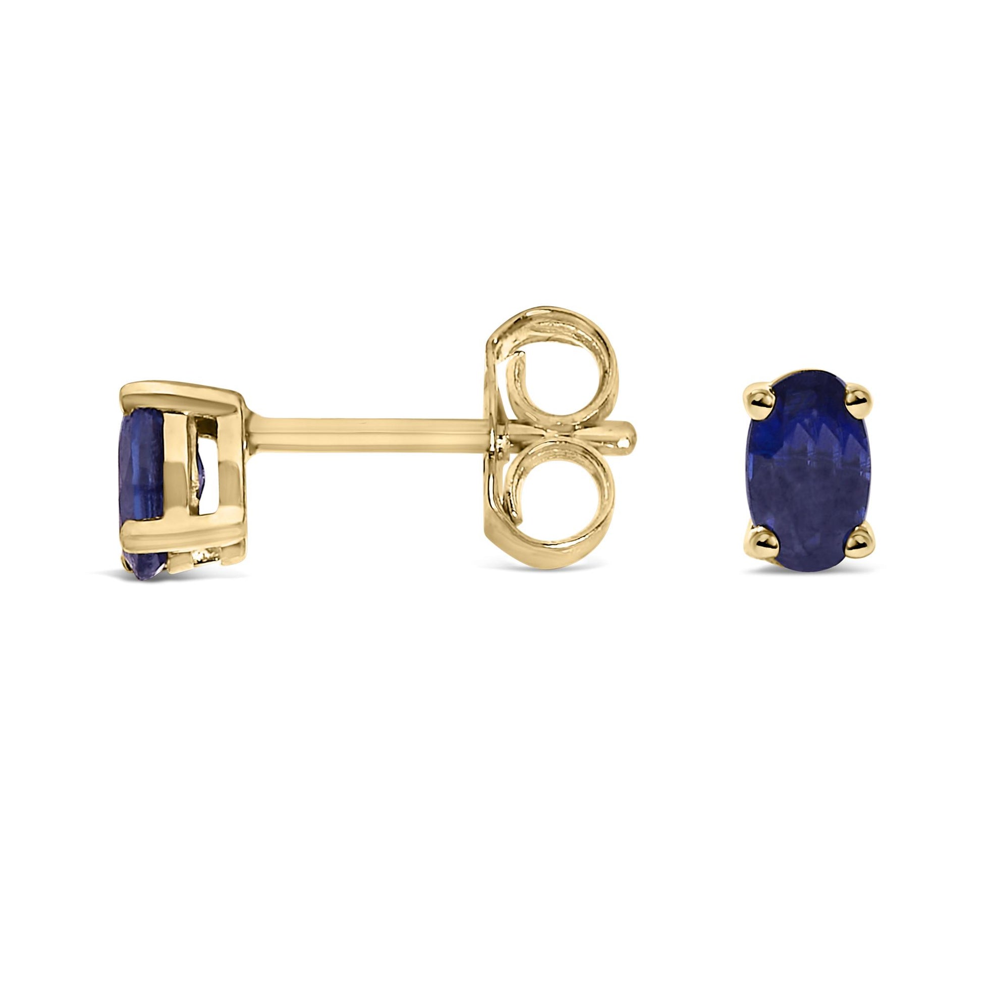 Front and side view of yellow metal stud earrings with oval blue gemstones in prong settings, shown against a white background.