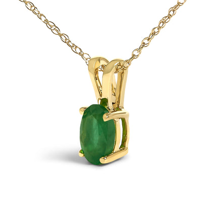 Close-up front angled view of a yellow metal necklace featuring a single oval green gemstone in a four-prong setting.