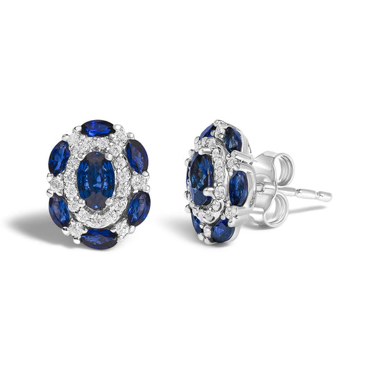 Pair of white metal stud earrings with oval and marquise blue gemstones surrounded by small round white gemstones, shown from front and side angles on a white background.