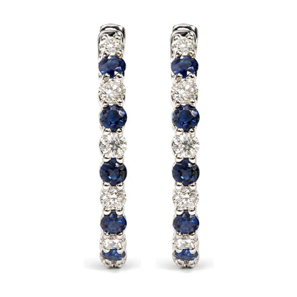 Pair of white metal hoop earrings shown from front, featuring alternating round white and blue gemstones in prong settings.
