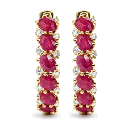 Close-up front view of a pair of yellow metal earrings featuring oval red gemstones and round white gemstones in prong settings.
