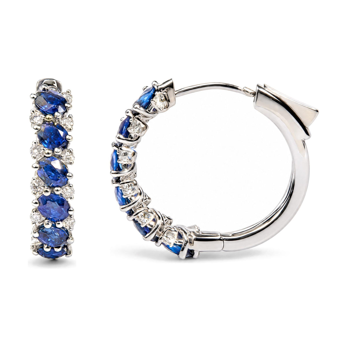 Close-up front and side view of white metal hoop earrings featuring multiple oval blue gemstones and round white gemstones in prong settings, shown on a white background.