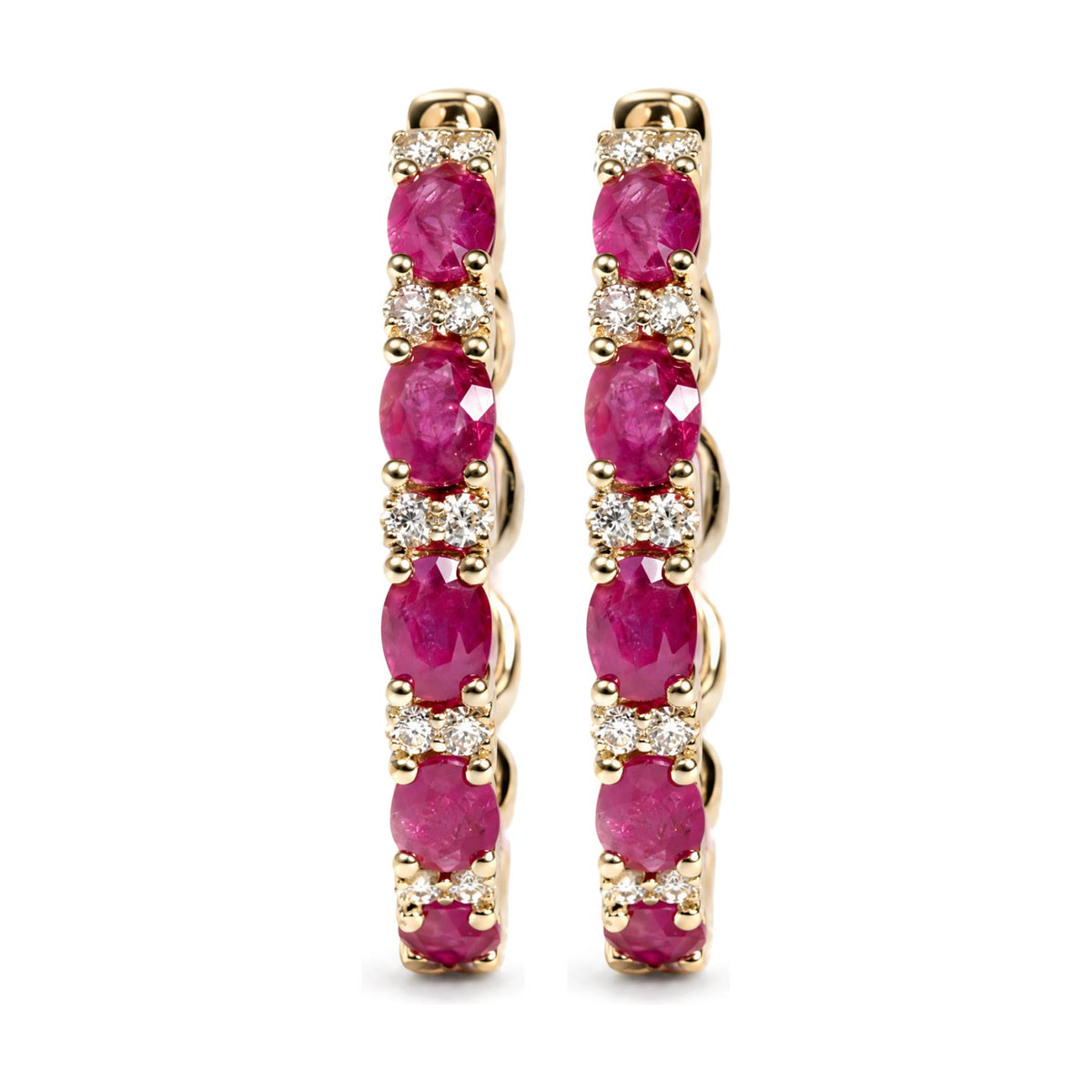 Close-up front view of a pair of yellow metal hoop earrings featuring alternating oval red gemstones and round white gemstones in prong settings, shown on a white background.