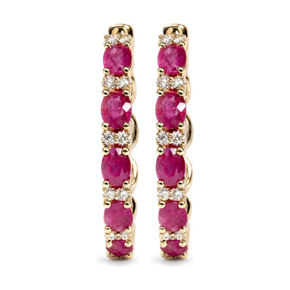 Close-up front view of a pair of yellow metal hoop earrings featuring alternating oval red gemstones and round white gemstones in prong settings, shown on a white background.