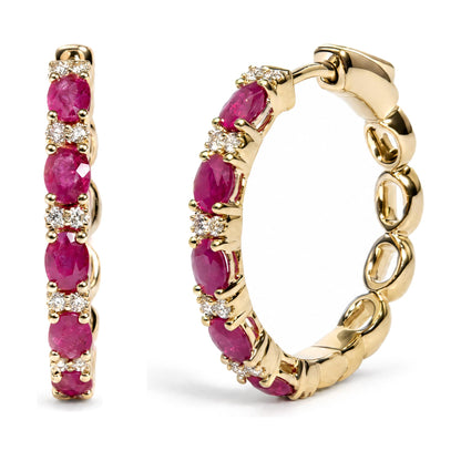 Close-up side angle of yellow metal hoop earrings set with alternating oval red gemstones and round white gemstones in prong settings.