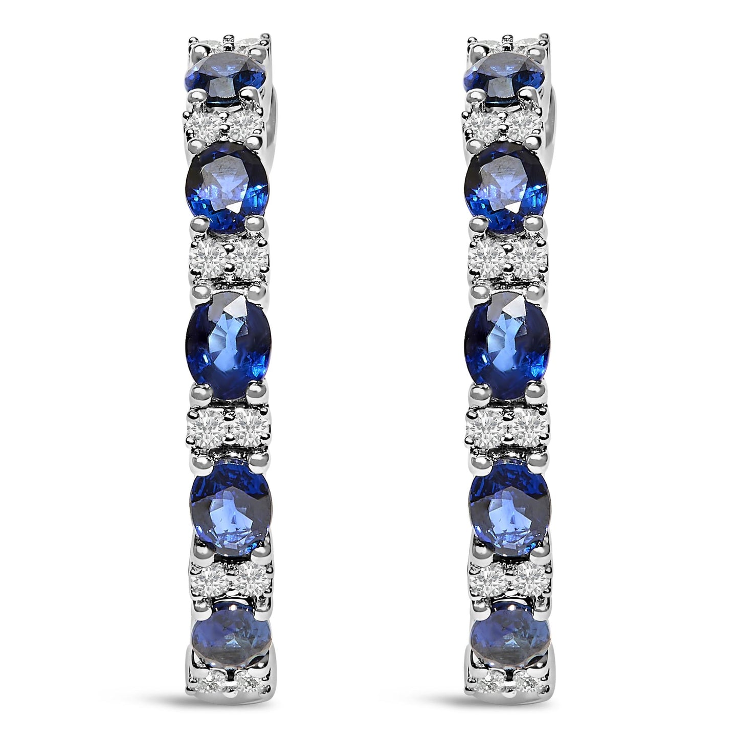 Front view of pair of white metal earrings featuring alternating oval blue gemstones and round white gemstones in shared prong and 4-prong settings.