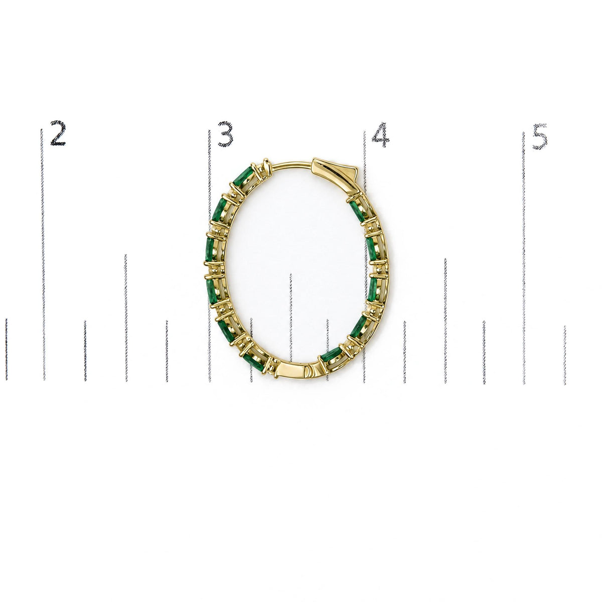 Close-up front angle of a yellow metal hoop earring set with alternating green marquise-shaped gemstones and white round-shaped gemstones in prong settings shown on a scale.
