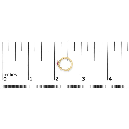 Yellow metal circular earring with red pear-shaped gemstone and small white round gemstones, shown on a ruler scale from above.