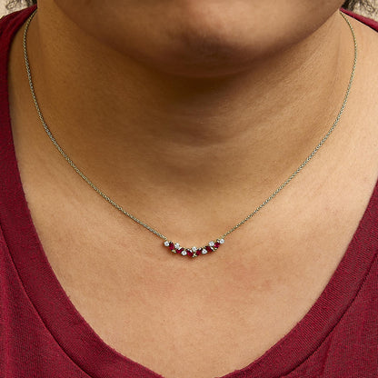 Close-up front view of yellow necklace with alternating red marquise-shaped gemstones and white round gemstones shown worn on a model.