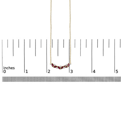 Yellow metal necklace with alternating marquise-shaped red gemstones and round white gemstones in prong settings, shown on a measuring scale, front view.