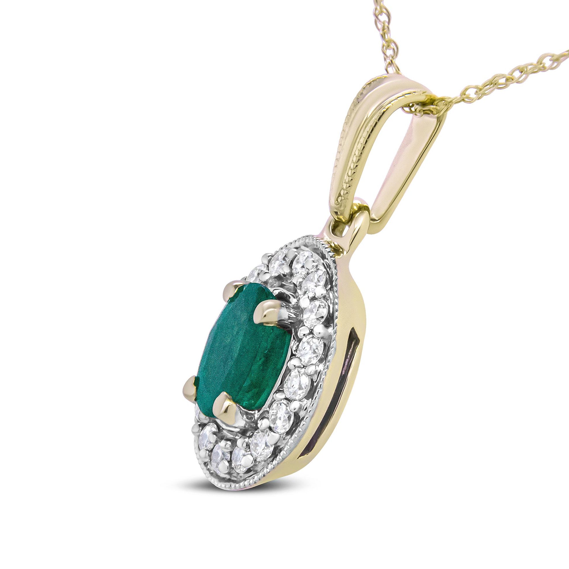 Yellow metal necklace pendant with an oval green gemstone center surrounded by small round white gemstones, shown in a close-up angled side view.