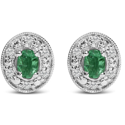 Pair of white metal oval earrings with central green oval gemstones surrounded by round white gemstones in pave setting, shown from front angle on a white background.