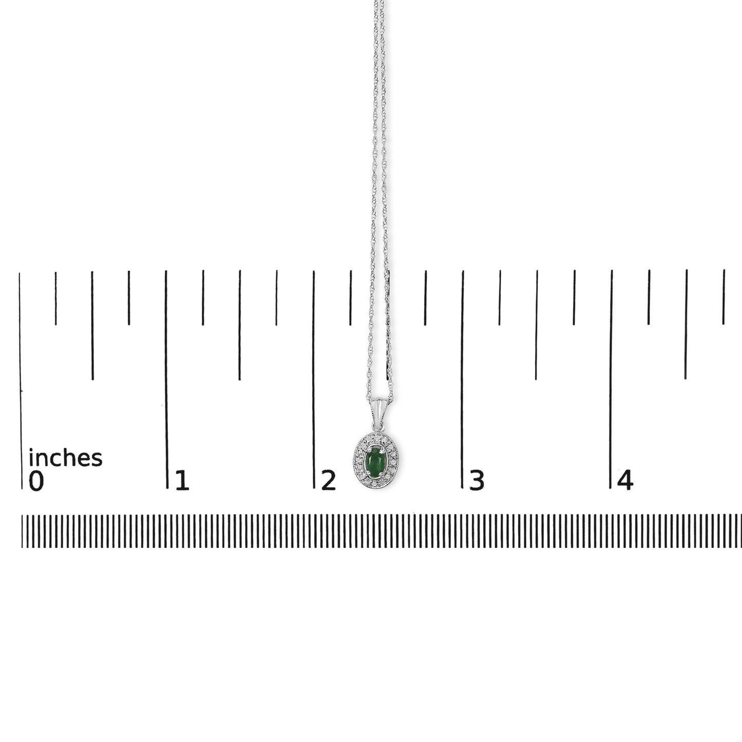 White metal necklace with an oval-shaped green gemstone pendant surrounded by round white gemstones in a pave setting, shown hanging centered on a measuring scale, front angle.