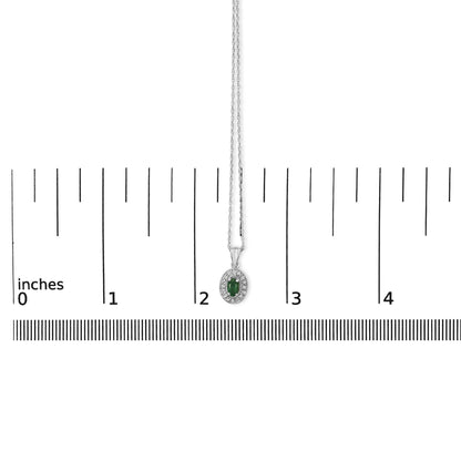 White metal necklace with an oval-shaped green gemstone pendant surrounded by round white gemstones in a pave setting, shown hanging centered on a measuring scale, front angle.