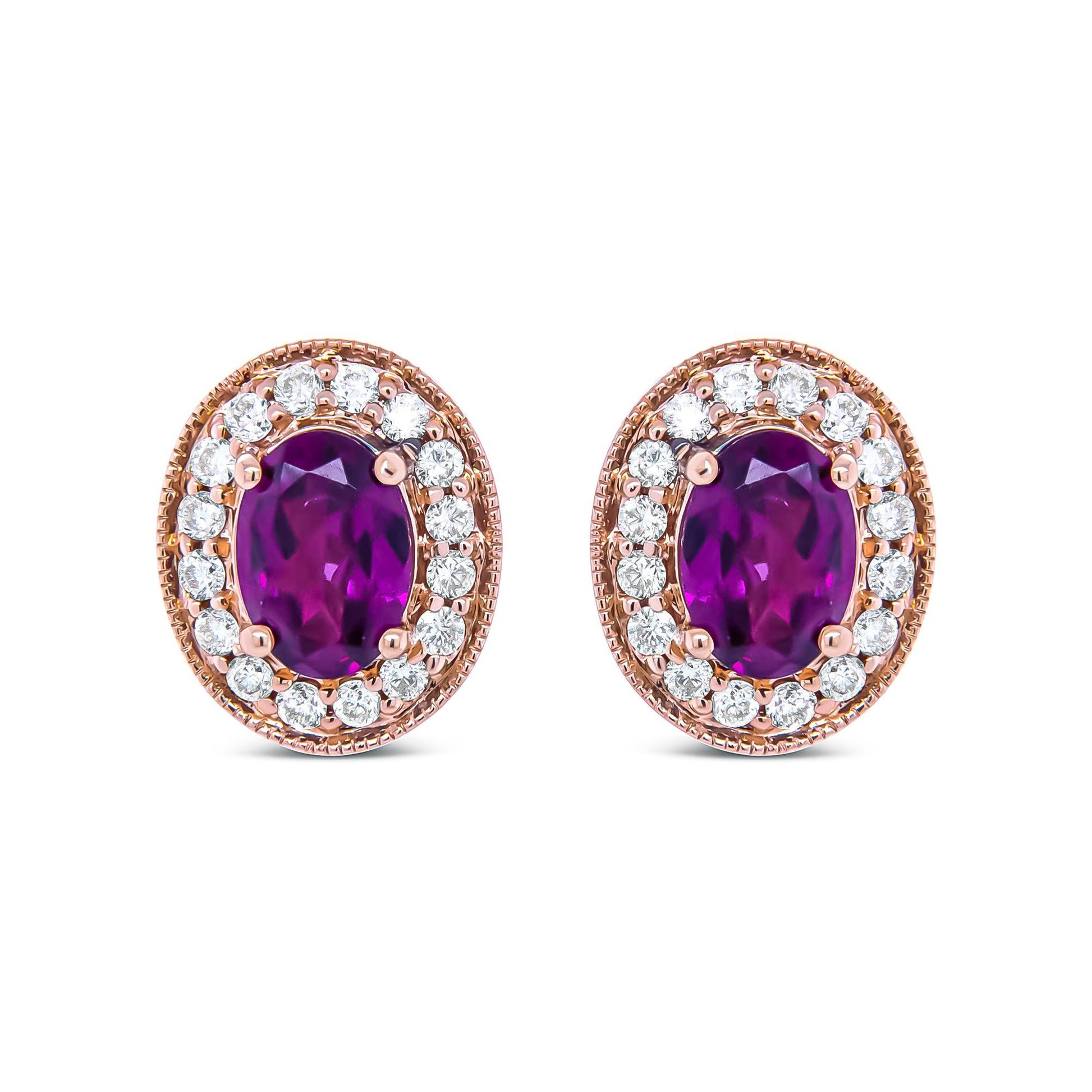 Close-up front view of a pair of rose metal oval earrings featuring a large oval red gemstone surrounded by a halo of round white gemstones in prong settings.