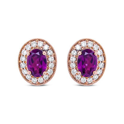 Close-up front view of a pair of rose metal oval earrings featuring a large oval red gemstone surrounded by a halo of round white gemstones in prong settings.