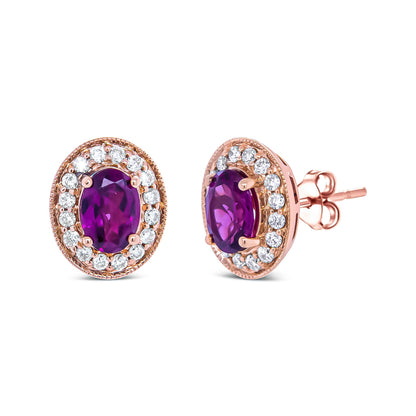Pair of rose metal stud earrings with oval-shaped red and purple gemstones at the center, surrounded by a halo of round white gemstones, shown in a front and angled side view.