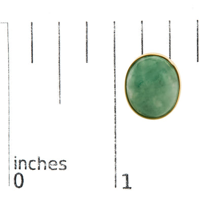 Close-up color image showing one oval-shaped green gemstone in a bezel setting on a yellow metal earring, positioned on a measuring scale.