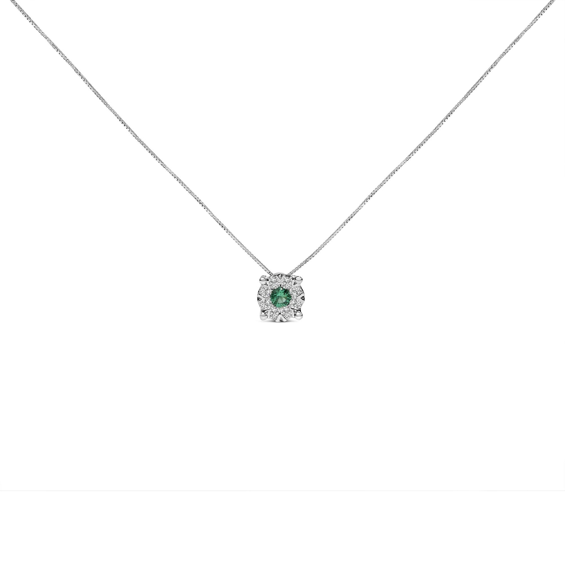 Front-facing shot of a white metal necklace with a pendant featuring a round green gemstone in a prong setting, surrounded by eight round white gemstones in a pave setting.