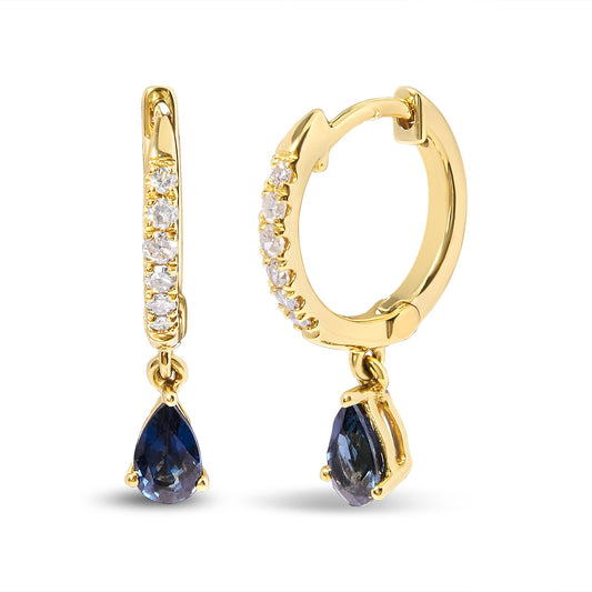 Pair of yellow metal hoop earrings with white gemstones set along the front and dangling pear-shaped blue gemstones, shown from front and side angles.