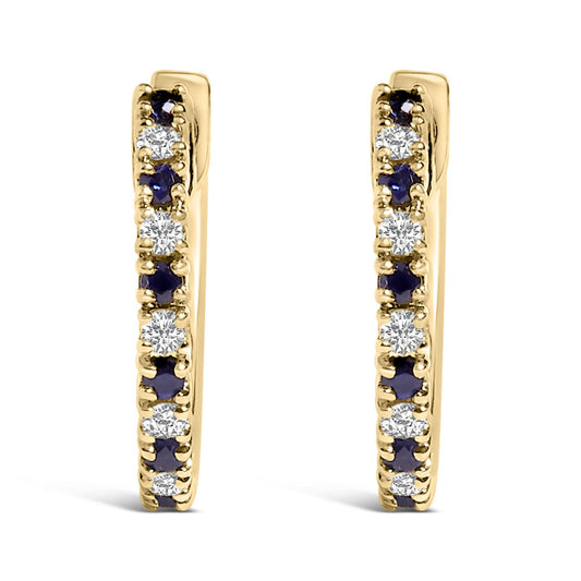 Front view of a pair of yellow metal hoop earrings set with alternating round white and blue gemstones in prong settings.