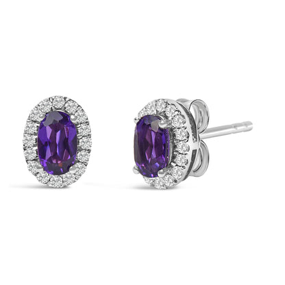 Pair of white metal stud earrings with oval purple gemstones surrounded by a halo of round white gemstones, shown from front and side angles.