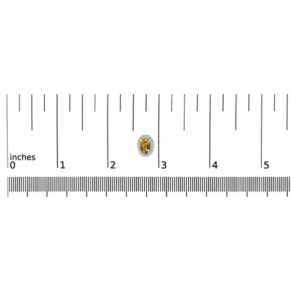 Close-up top view of a single white metal earring with a yellow oval gemstone surrounded by small white round gemstones, placed on a ruler for size reference.