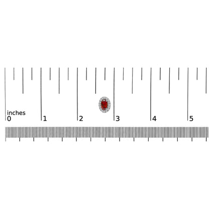 White metal earring with a red oval gemstone surrounded by a halo of round white gemstones, shown on a ruler for size reference, front-facing angle.