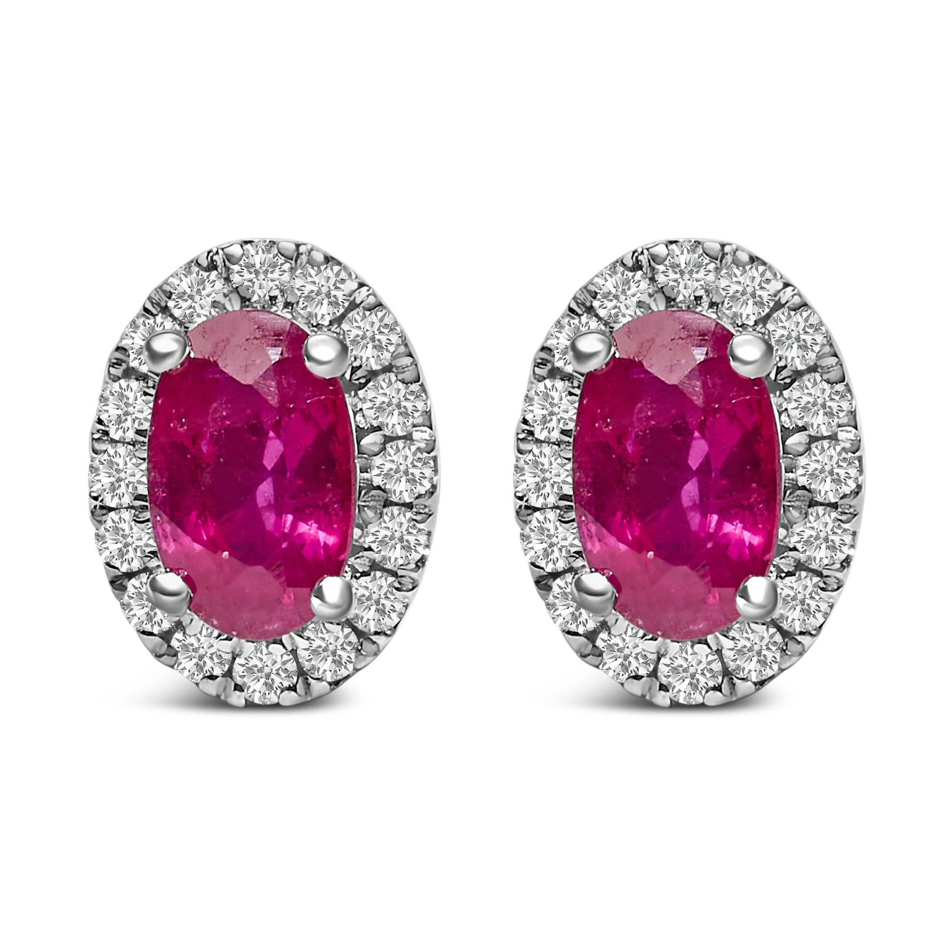 Pair of white metal oval earrings with central red oval gemstones surrounded by a halo of small round white gemstones, shown from front angle.