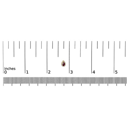 Close-up front view of a yellow metal earring with a pear-shaped red gemstone surrounded by pave-set round white gemstones, shown on a ruler for size reference.