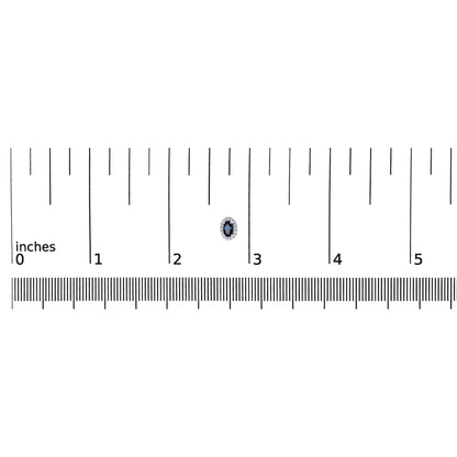 Close-up front view of a white metal earring with an oval blue gemstone in the center surrounded by small round white gemstones, shown on a ruler for size reference.