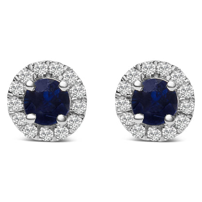 Front view of white metal round stud earrings featuring a central round blue gemstone with surrounding round white gemstones in a pave setting.