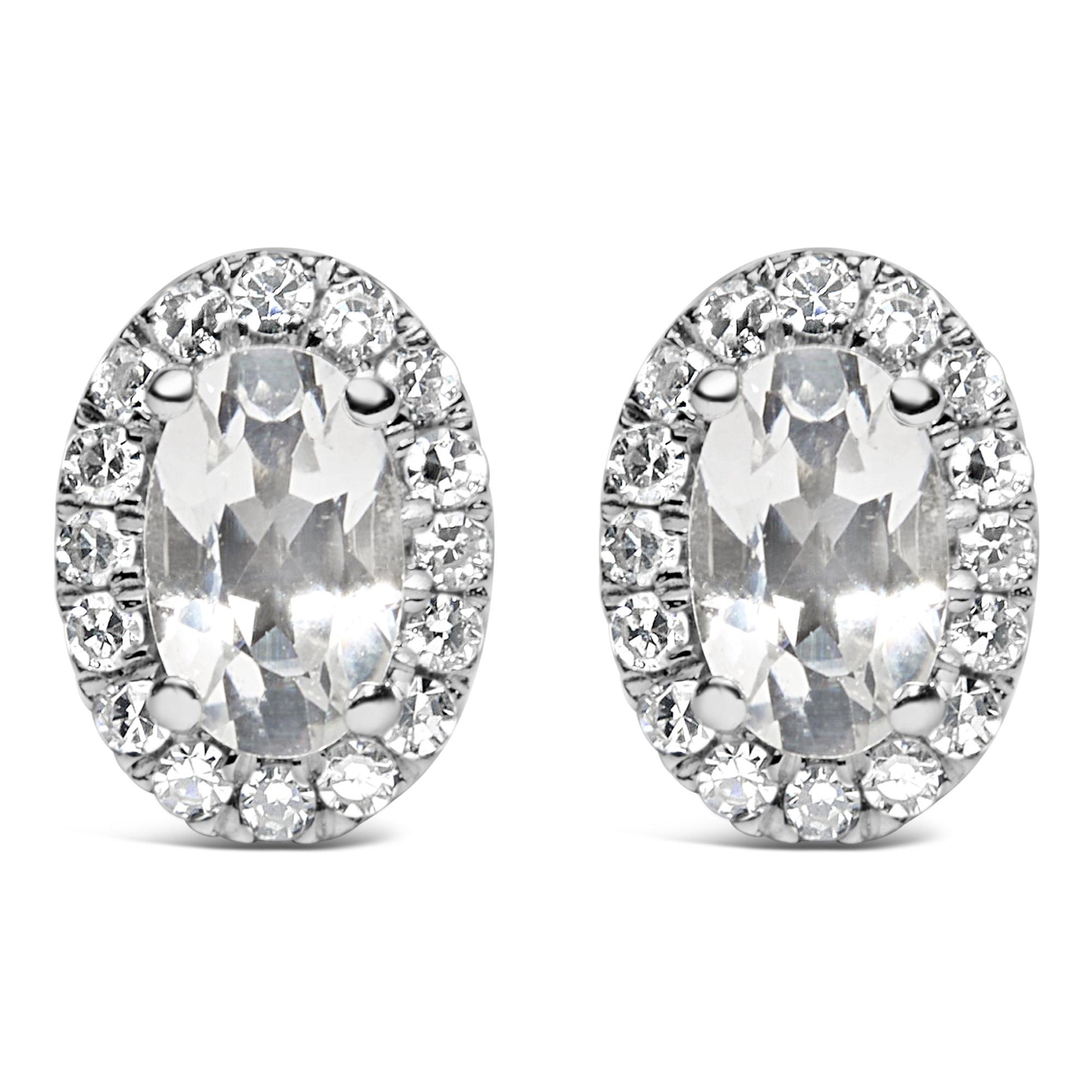 Front angle view of white metal oval-shaped stud earrings with central oval white gemstones in four-prong settings, surrounded by a pave setting of round white gemstones.