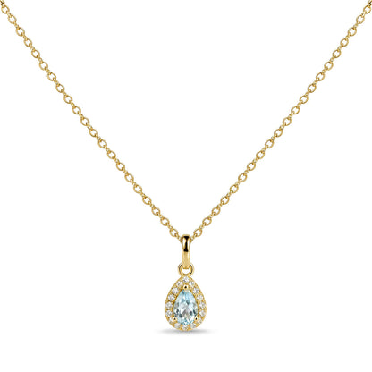 Close-up front view of a yellow metal necklace with a pear-shaped blue gemstone pendant surrounded by small round white gemstones in prong settings.