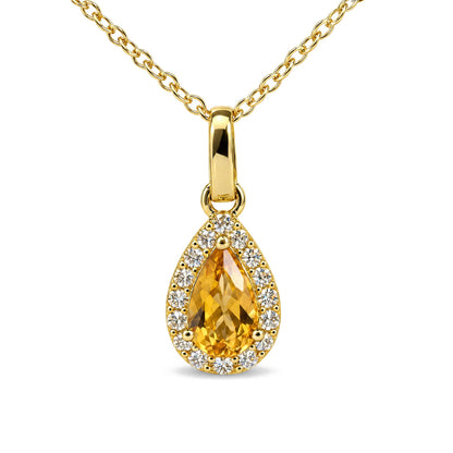 Close-up front view of a yellow metal necklace with a pear-shaped yellow gemstone pendant surrounded by round white gemstones in prong settings.