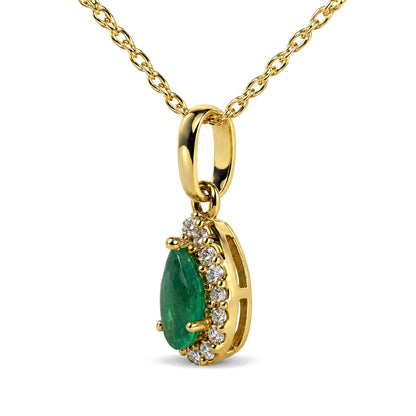 Close-up front angle of a yellow metal necklace chain with a pendant featuring a pear-shaped green gemstone surrounded by small round white gemstones in prong settings.