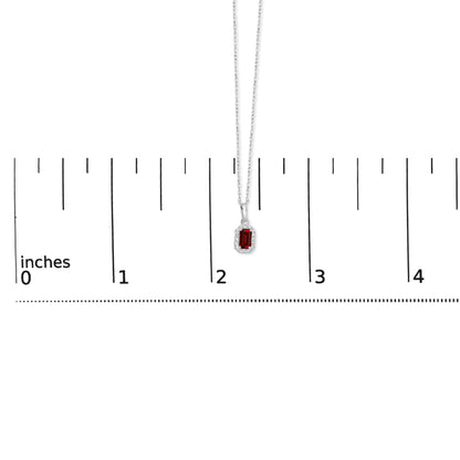 White metal necklace with a rectangular red gemstone pendant surrounded by small white gemstones in a micro-pave setting, shown hanging vertically against a ruler for size reference.
